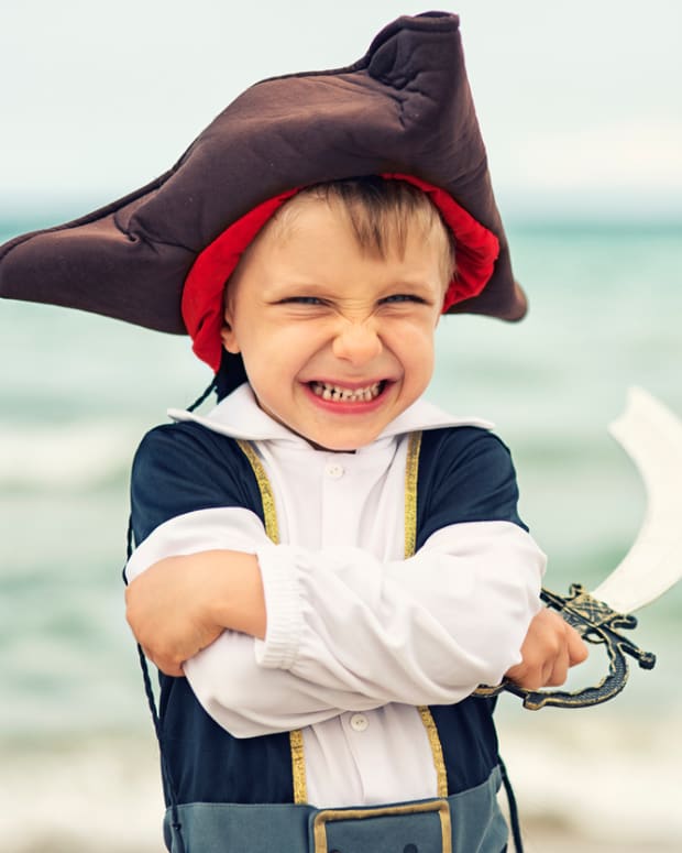 Little boy dressed up as a pirate laughing at a joke